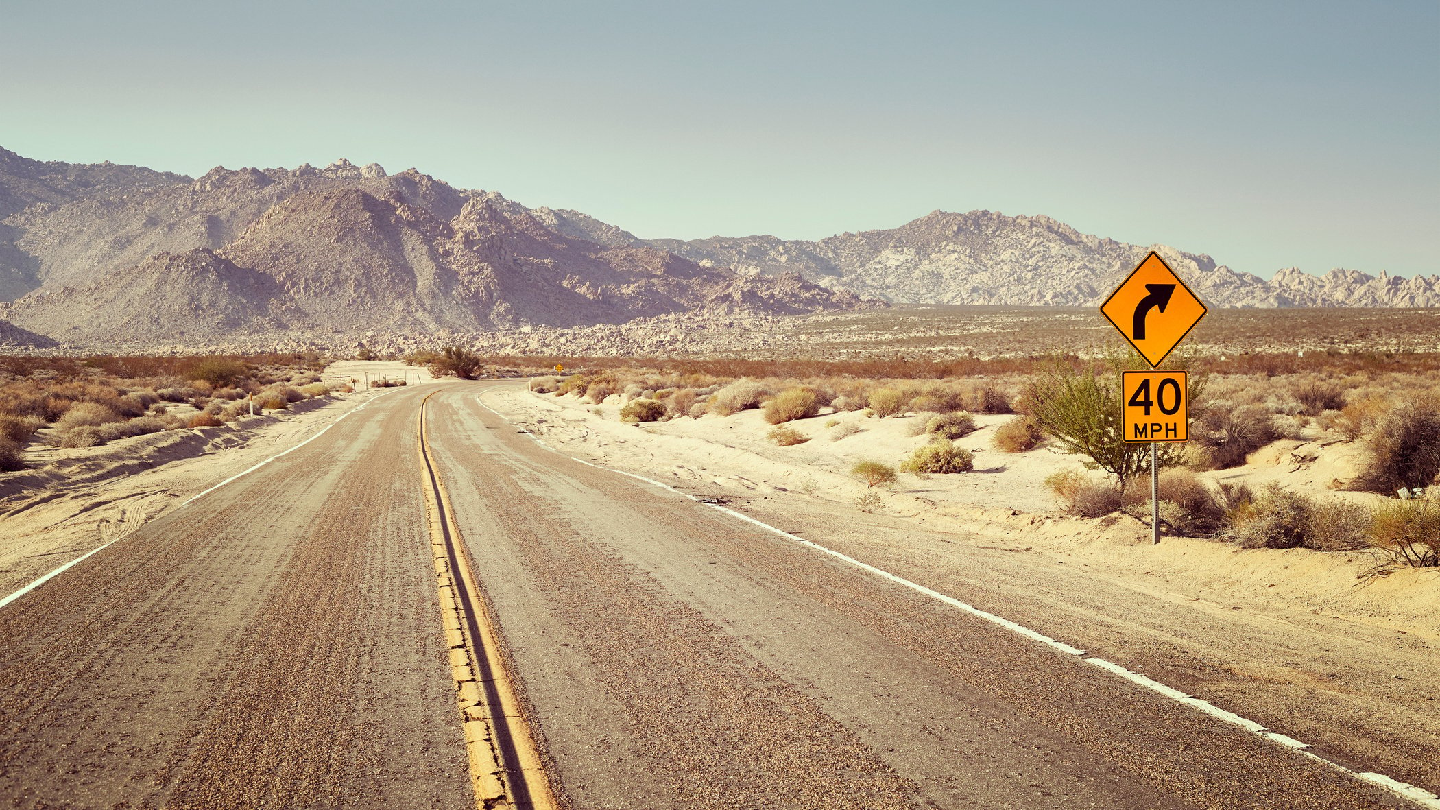 Desert Highway with Speed Limit Sign